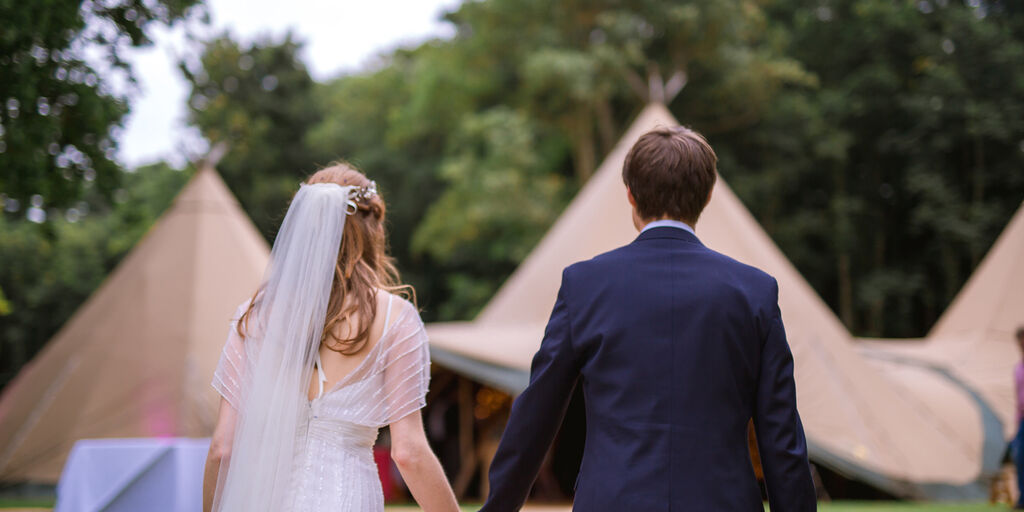A bride & groom walk towards the Tipi wedding venue site in County Down, Northern Ireland