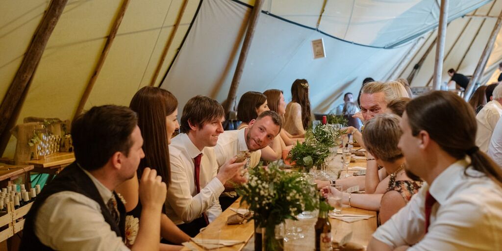 Wedding guests celebrate at a reception held inside a Tipi