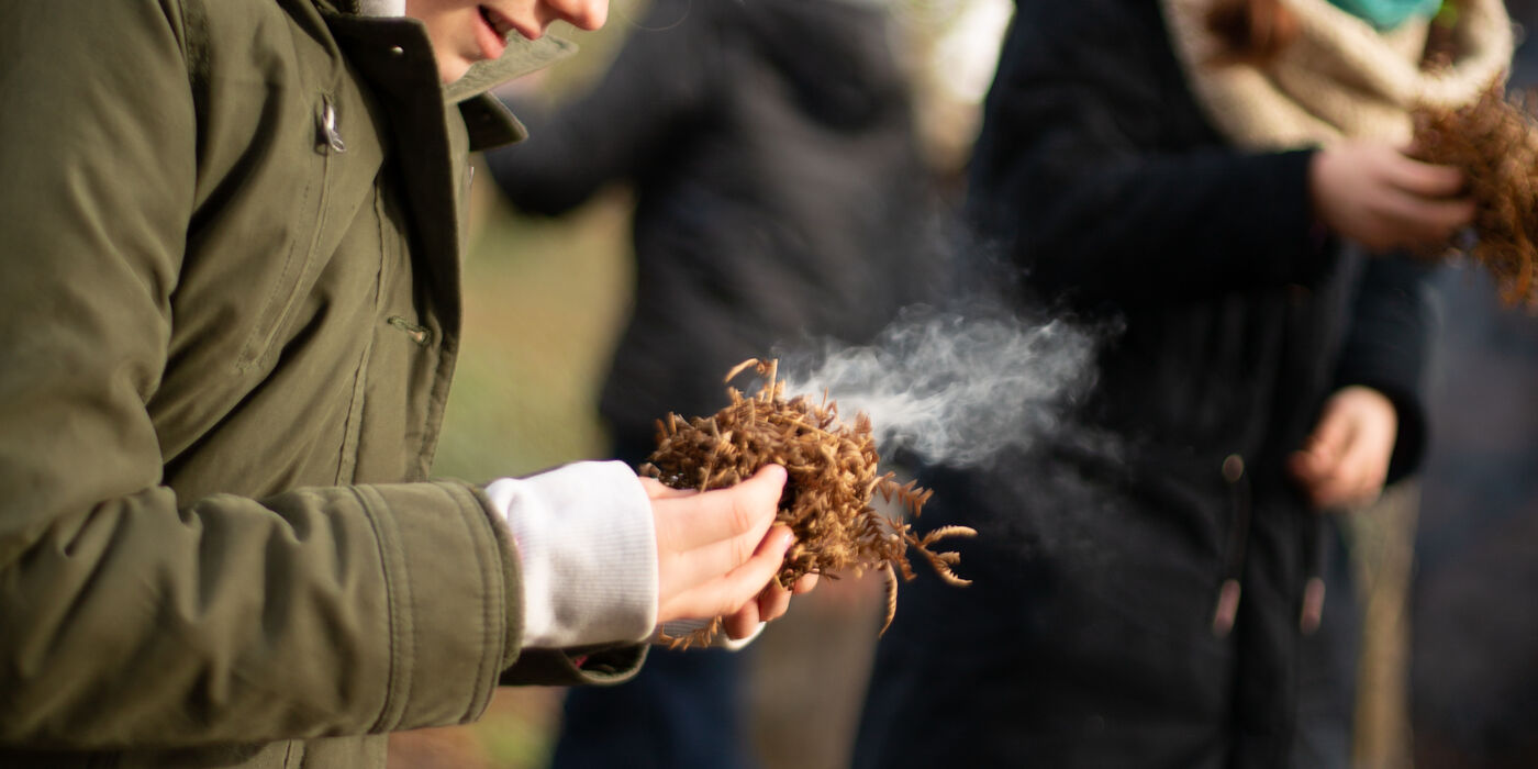 Young girl makes a fire at the Finnebrogue Woods School of Bushcraft Easter Camp