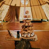 Donuts decorate a wooden log stand at the centre of a tipi