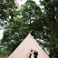 Father of the bride walks the bride out of the bridal tipi at the sacred ceremony site at Finnebrogue Woods