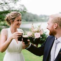 Bride & groom cheers their guiness at Finnebrogue Woods tipi wedding venue
