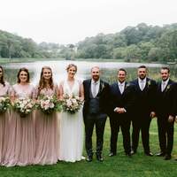 Wedding party pose for a photograph in front of Finnebrogue Lake