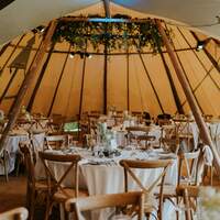Finnebrogue Woods wedding tipi venue is decorated with wild foliage in a rustic style