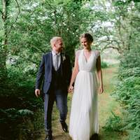 Bride & groom walk down the mossy path into ancient woodland at Finnebrogue Woods