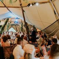Wedding guests listen to speeches and have a laugh inside Finnebrogue Woods tipi venue