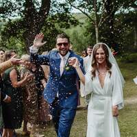 Bride & groom cheer and walk through confetti & their wedding guests at Finnebrogue Woods