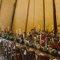 Tipi is decorated in a rustic wedding style with wildflowers
