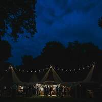 Finnebrogue Woods wedding venue Tipi are lit up at night with festoon lighting