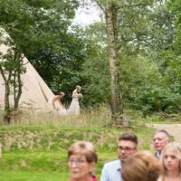 The bride walks out from the bridal tipi for her wedding ceremony to take place
