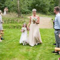 A bridesmaid & flowergirl walk down the aisle at Finnebrogue Woods ceremony site