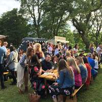 Corporate guests sit outsde for food at a summer party in Finnebrogue Woods located in County Down